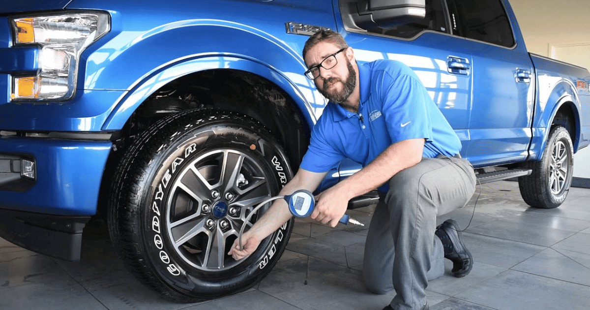 a technician checking tire pressure in ford f 150 to showcase  the importance of essential maintenance.