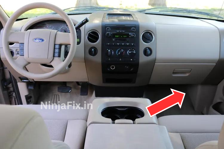 an image of the ford f-150 dashboard with read box and arrow to highlights the fuse box of passenger compartment to demonstrate the location of radio fuse box location .